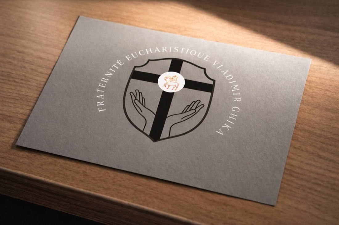 L’emblème de la Fraternité imprimé sur un carton gris posé sur un bureau de bois.